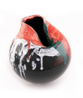 Kulovitá váza se záměrně deformovaným vpadlým hrdlem černě glazovaná s barevnou naglazurní malbou.