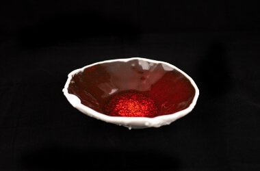 Porcelánová miska ve tvaru houby s efektní červenou glazurou.