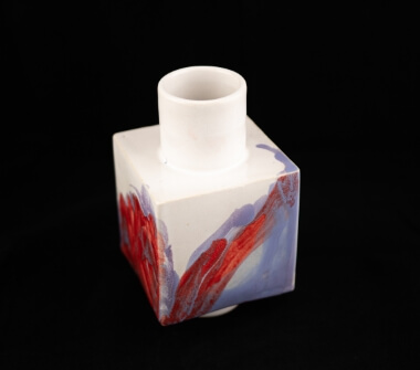 Váza z lité kameniny odkazující k principům kubismu a abstraktního umění v bílé glazuře dekorována ruční malbou.